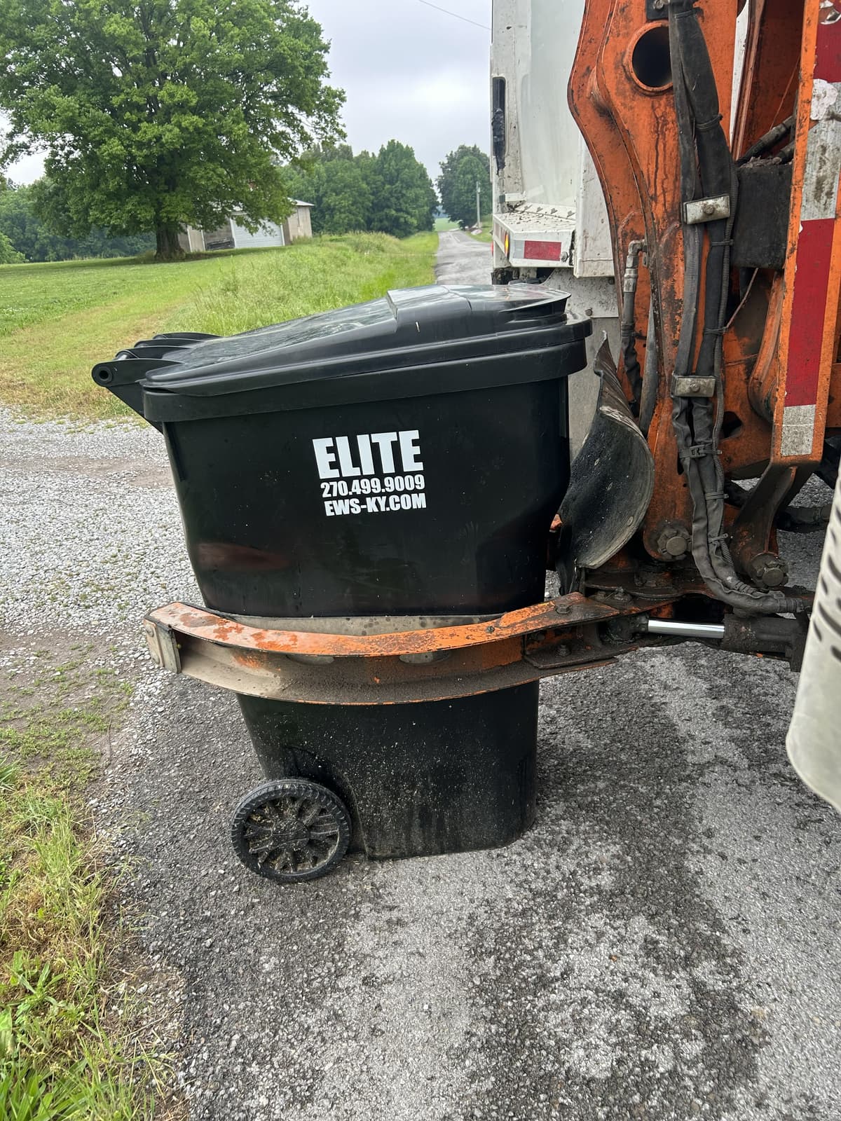 Elite Waste Services branded trash carts positioned in a residential neighborhood in Kentucky