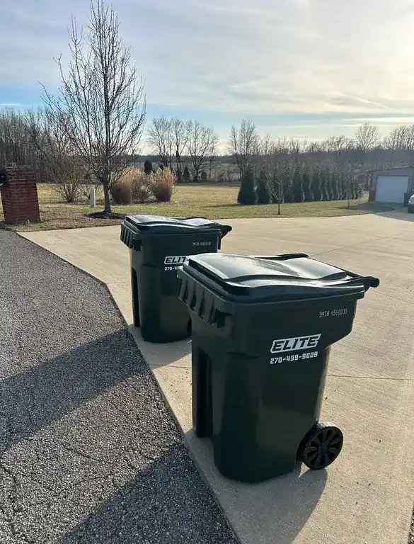 Elite Waste Services branded trash carts positioned in a residential neighborhood in Kentucky