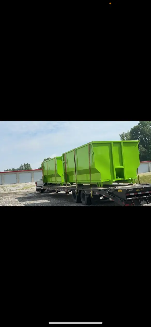 Elite Waste Service truck transporting multiple green dumpsters, showcasing our fleet and operations in Kentucky